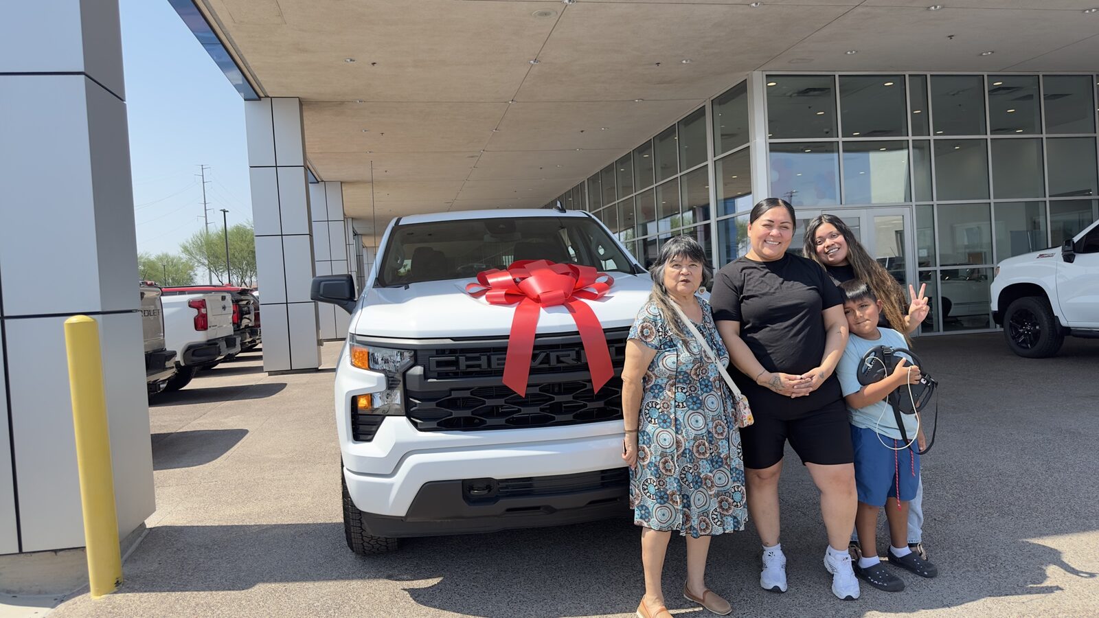 Family posing with their new white Silverado